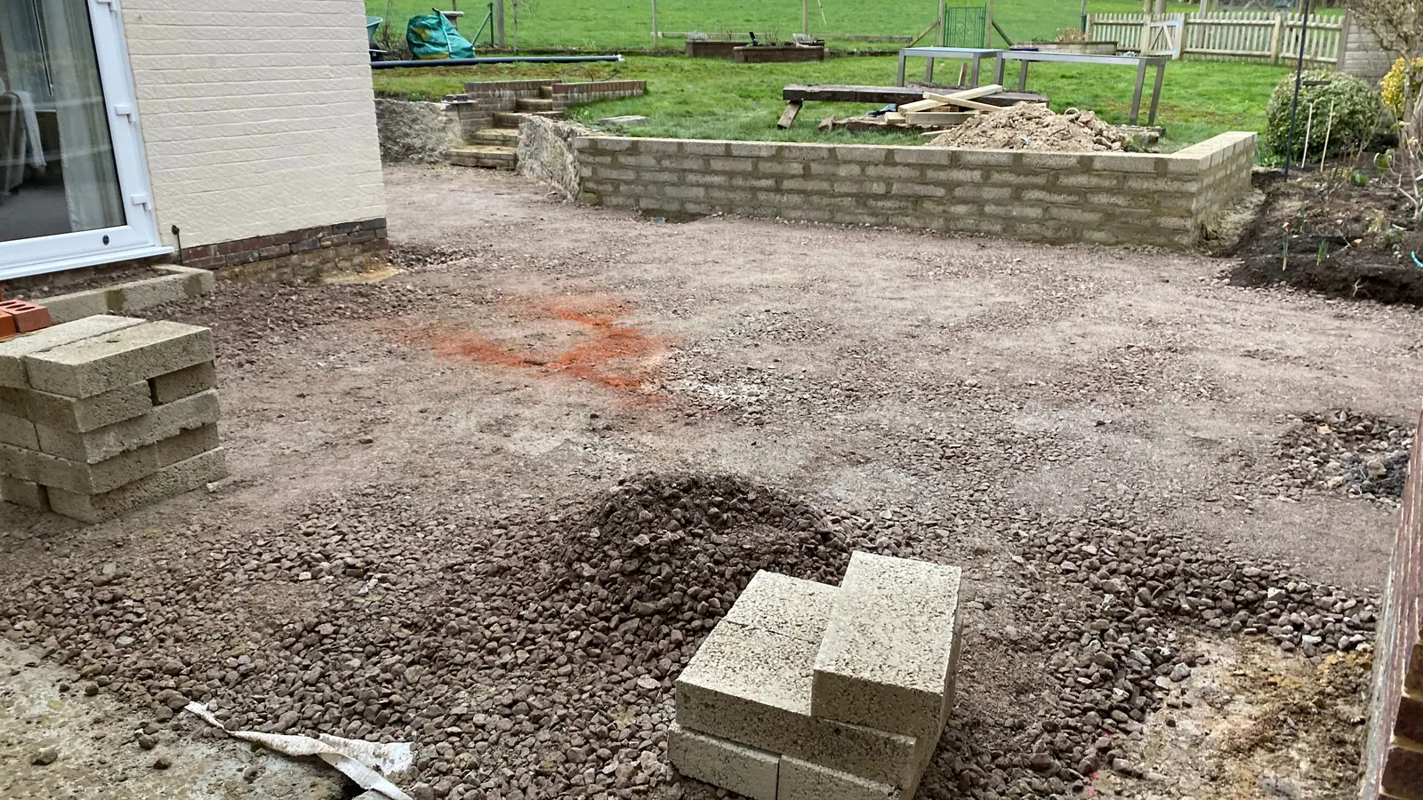 Sub-base laid outside French doors, with a new block retaining wall going up behind